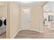 Bright foyer showcasing wood-look flooring with access to the laundry room and a glimpse of the modern kitchen at 9923 Sw 98Th Ln, Ocala, FL 34481