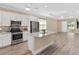 Modern kitchen with stainless steel appliances, a center island with granite countertop, and wood-look floors at 9923 Sw 98Th Ln, Ocala, FL 34481