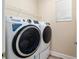 Modern laundry room featuring front-load washer and dryer, with overhead shelving at 9923 Sw 98Th Ln, Ocala, FL 34481
