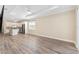 Bright living room with stylish wood floors, a tray ceiling, and an open floor plan to the kitchen at 9923 Sw 98Th Ln, Ocala, FL 34481