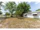 Well-maintained backyard with a mix of grass and shaded areas, enclosed by a chain-link fence for added security at 9940 Sw 103Rd Pl, Ocala, FL 34481