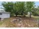 Serene backyard featuring mature trees and a charming stone table with benches at 9940 Sw 103Rd Pl, Ocala, FL 34481