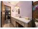 Bright bathroom featuring a cream-colored vanity and an adjacent open walk-in closet at 9940 Sw 103Rd Pl, Ocala, FL 34481