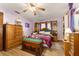 Spacious bedroom featuring wood floors, lavender walls, and custom wood storage cabinets at 9940 Sw 103Rd Pl, Ocala, FL 34481