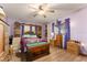 Spacious bedroom featuring wood floors, lavender walls, and custom wood storage cabinets at 9940 Sw 103Rd Pl, Ocala, FL 34481