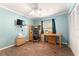 Bedroom with blue walls, ceiling fan, wood floors, desk, and a closet with bi-fold doors at 9940 Sw 103Rd Pl, Ocala, FL 34481