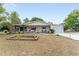 Single-story home with a covered front porch, a small garden, and an attached garage at 9940 Sw 103Rd Pl, Ocala, FL 34481