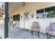 Inviting covered porch with chairs and decorative accents creating a warm entrance at 9940 Sw 103Rd Pl, Ocala, FL 34481