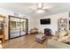 Bright living room with a large window, ceiling fan, sliding doors, and modern flooring at 9940 Sw 103Rd Pl, Ocala, FL 34481