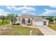 Inviting single-story home features a neutral color palette, arched windows, and a well-manicured lawn under a bright sky at 5245 Nw 21St Loop, Ocala, FL 34482
