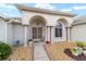 Welcoming front porch with arched entrance, decorative plants, and stone accents leading to the front door at 5245 Nw 21St Loop, Ocala, FL 34482