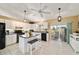 Well-lit kitchen with white cabinets, tile floors, an island with bar stools, and a view of the backyard at 5245 Nw 21St Loop, Ocala, FL 34482