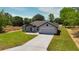 Aerial view of a single-story home with a two-car garage and a long driveway, set on a spacious, green lot at 112 Juniper Run, Ocala, FL 34472