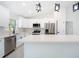 Modern kitchen featuring white cabinetry, stainless steel appliances, and a large center island with quartz countertops at 112 Juniper Run, Ocala, FL 34472