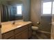 Well-lit bathroom with vanity, sink, toilet, and white cabinets at 11411 Sw 138Th Ln, Dunnellon, FL 34432