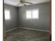 Lovely bedroom with wood-look tile flooring, ceiling fan, and ample natural light at 11411 Sw 138Th Ln, Dunnellon, FL 34432