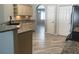 Open kitchen with stainless steel appliances, granite countertops, wood cabinets and wood-look flooring at 11411 Sw 138Th Ln, Dunnellon, FL 34432