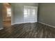 Stylish living room with wood-look tile flooring, archway, and white window shutters at 11411 Sw 138Th Ln, Dunnellon, FL 34432