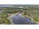 Panoramic aerial view of private lake with lily pads, surrounded by trees and some homes at 1179 Se 170Th Ct, Silver Springs, FL 34488