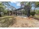 Exterior view of a screened-in pool and backyard surrounded by mature trees and lush landscaping at 1179 Se 170Th Ct, Silver Springs, FL 34488