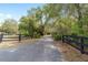 Long, paved driveway leading to the property, framed by a rustic black wooden fence at 1179 Se 170Th Ct, Silver Springs, FL 34488