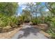 Paved driveway bordered by lush greenery and mature trees, providing a private entrance at 1179 Se 170Th Ct, Silver Springs, FL 34488