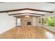 The living room has hardwood floors, exposed beams, natural lighting, and a stone fireplace at 1179 Se 170Th Ct, Silver Springs, FL 34488