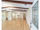 An open concept living room with hardwood floors, exposed beams, natural light and views into the kitchen at 1179 Se 170Th Ct, Silver Springs, FL 34488