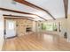 A bright living room with a stone fireplace, exposed beams, hardwood floors, and natural lighting at 1179 Se 170Th Ct, Silver Springs, FL 34488