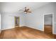 Bright bedroom features hardwood floors, a ceiling fan, and a unique glass panel sliding door at 14171 Sw 8Th Ave, Ocala, FL 34473