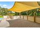 An outdoor deck with a shade cover, overlooking the scenic backyard at 14171 Sw 8Th Ave, Ocala, FL 34473
