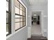 Hallway with white tile flooring, views of the kitchen and an outside view through windows at 14171 Sw 8Th Ave, Ocala, FL 34473