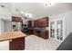 Kitchen showcasing dark wood cabinets, stainless appliances, island, and tile flooring at 14171 Sw 8Th Ave, Ocala, FL 34473