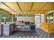 Outdoor kitchen with a built-in grill, sink, mini-fridge, and tiled backsplash at 14171 Sw 8Th Ave, Ocala, FL 34473