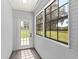 A cozy porch with plank-paneled walls, large windows, and an inviting glass-paneled door at 14171 Sw 8Th Ave, Ocala, FL 34473