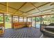 Enclosed sun room featuring a cozy built-in bench and checkerboard flooring, perfect for relaxing at 14171 Sw 8Th Ave, Ocala, FL 34473