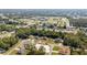An aerial view shows houses surrounded by green trees, with a school in the background at 15087 Sw 43Rd Ct, Ocala, FL 34473