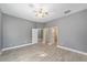 Bedroom featuring laminate flooring, neutral paint, ceiling fan, and multiple doorways at 15087 Sw 43Rd Ct, Ocala, FL 34473