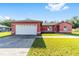 Single-Gathering home with a two-car garage, large driveway and a well-maintained front lawn at 15087 Sw 43Rd Ct, Ocala, FL 34473