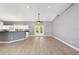 Bright living room with wood-look floors, ceiling fan, and French doors to backyard at 15087 Sw 43Rd Ct, Ocala, FL 34473