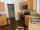 Functional kitchen featuring wood cabinets, stainless steel appliances, and views into the laundry area at 15266 Sw 44Th Ter, Ocala, FL 34473
