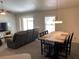 Inviting living room features a rustic wooden table, chandelier, and plentiful natural light from windows with blinds at 15266 Sw 44Th Ter, Ocala, FL 34473
