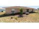 Home's backyard with ample space, sliding glass doors, and a large garden area at 173 Juniper Way, Ocala, FL 34480