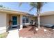 Inviting front entrance with a turquoise door, complemented by a palm tree and landscaped mulch bed at 173 Juniper Way, Ocala, FL 34480