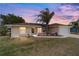 Charming single-story home with well-maintained lawn and a palm tree in the front yard at sunset at 173 Juniper Way, Ocala, FL 34480