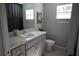 Well-lit bathroom featuring a gray countertop vanity, toilet, decor, and window at 18 Larch Radl, Ocala, FL 34480