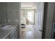 Bathroom view leading into bedroom with white door, sink, and wood flooring at 18 Larch Radl, Ocala, FL 34480