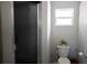 Bathroom featuring a toilet, walk-in shower with glass doors, and window at 18 Larch Radl, Ocala, FL 34480