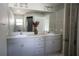 Bathroom showcasing a double sink vanity, with a large mirror, and gray cabinetry at 18 Larch Radl, Ocala, FL 34480