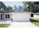 Spacious two car garage with clean concrete driveway and manicured landscaping at 18 Larch Radl, Ocala, FL 34480